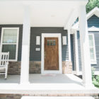 covered front porch with wood front door
